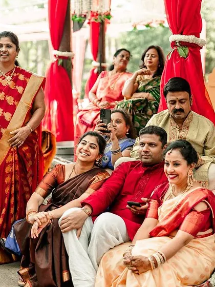 A candid shot of guests enjoying the ceremony. We make sure to photograph not just the main family but also the friends and relatives who are there to share in the joy.
