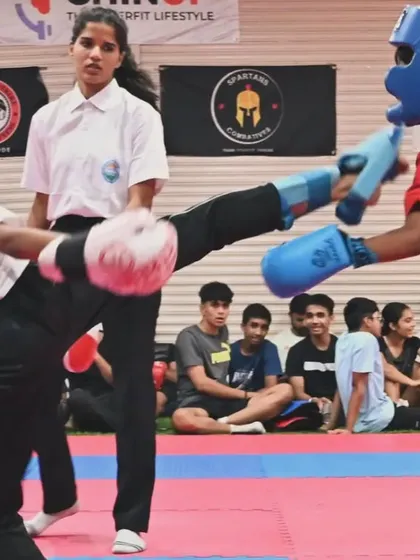 Precision in action. Here, one of our kickboxing students executes a powerful high kick during a competitive match. Our training focuses on developing the speed, technique, and confidence needed to perform effectively under pressure.