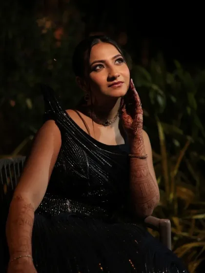 A dreamy, upward glance captures the magic of the evening. Her makeup is subtle yet defined, with a focus on luminous skin that catches the light beautifully.