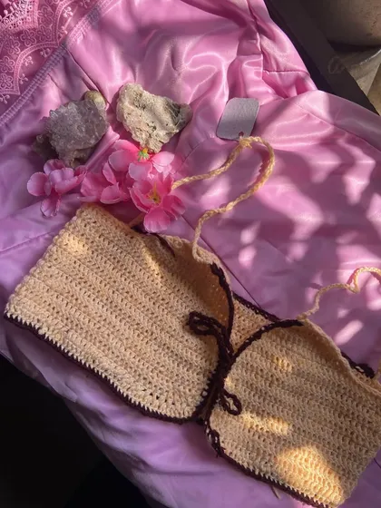 A close-up of one of my handmade halter bikini tops. This one shows a two-tone design with a light cream body and a dark brown border, but you can pick any color combo you want. The straps are fully adjustable for a perfect fit.