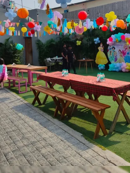 The outdoor dining setup for a princess party, with picnic-style tables ready for the royal guests.