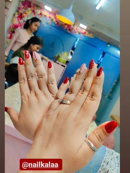 A client showing off her beautiful red and pink glitter manicure in the studio.