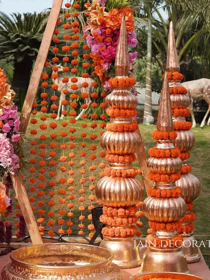Details matter in creating an authentic atmosphere. I used traditional copper-toned pots and marigold strings to add a rustic and sacred touch to the Haldi ceremony decor.