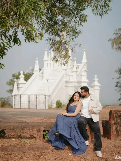 A relaxed portrait of the couple sitting together near the church, perfectly capturing a serene and happy moment.