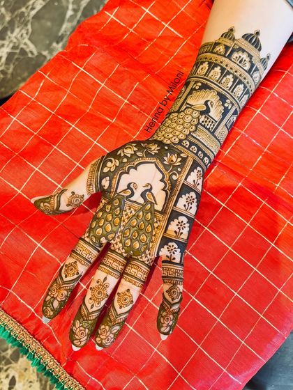 For brides who love detailed work, this design is a perfect choice. It features majestic peacocks in a Jharokha setting, surrounded by intricate patterns.