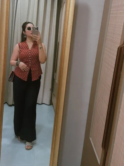 A mirror selfie showing the full silhouette of the red waistcoat and black pants outfit. This combination is a timeless classic, proving that the right pieces can be styled for years to come.