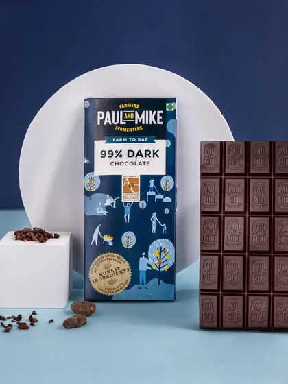 A 99% dark chocolate bar styled with a deep blue background and clean white blocks. The colour palette is chosen to reflect the intense and premium nature of the product.