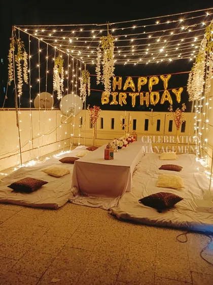 This cozy terrace setup is perfect for a relaxed birthday gathering. I created a canopy of lights with hanging white wisteria and set up mattresses and cushions for comfortable floor seating.