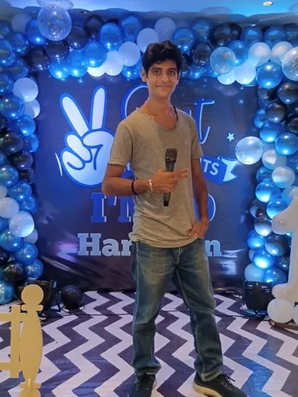 Posing in front of a cool 10th birthday backdrop before the show starts. Your Anchor Karan Rajani, ready for action.