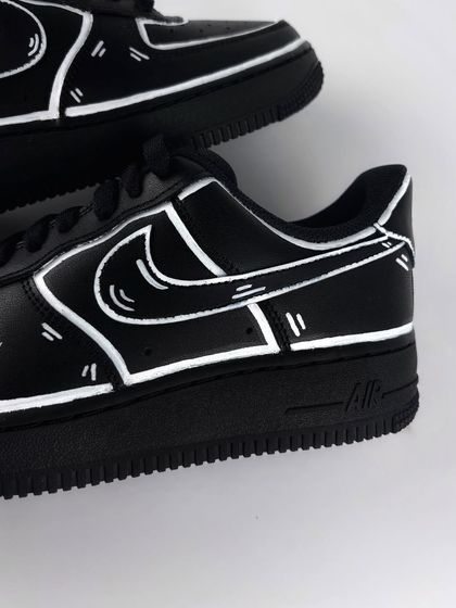 A detailed shot of the white outlines on the black cartoon custom sneaker.