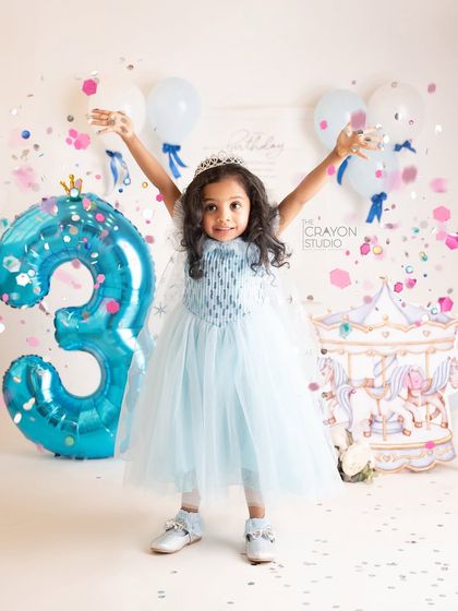 Celebrating with a shower of confetti. The birthday girl throws her hands up in the air with pure joy.