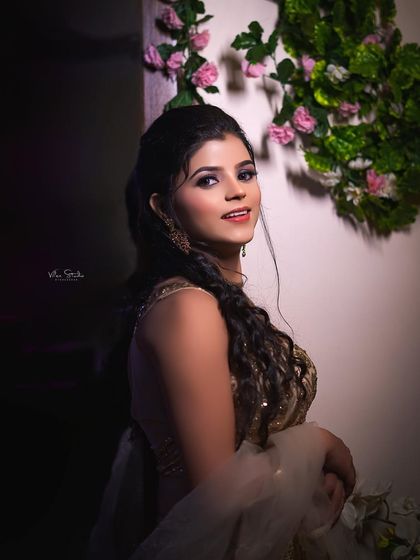 A beautiful portrait of the bride looking over her shoulder with a warm smile. The soft lighting highlights her features and the intricate details of her embroidered blouse.