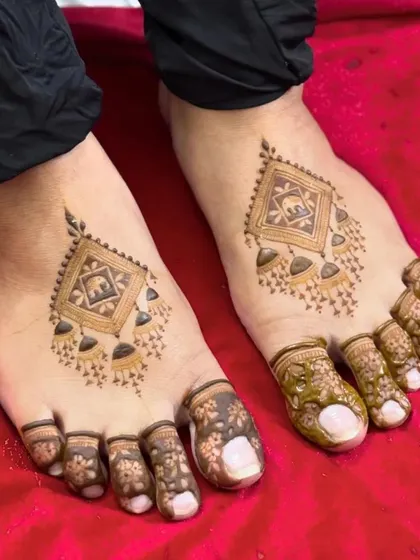 A unique and modern foot design featuring jhumka and elephant motifs inside a diamond shape.