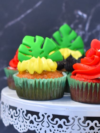 A close-up of the tropical pineapple cupcakes with monstera leaf toppers, showing the vibrant colors and fun designs from our cupcake class.