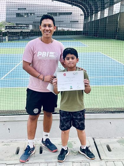 A proud moment between a coach and a young player with his certificate. These interactions build trust and motivate our athletes to keep striving.