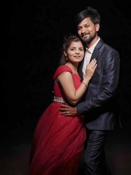 A classic indoor studio portrait for a pre-wedding shoot. The simple red tulle gown is a timeless and romantic choice.