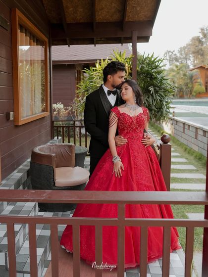 A tender moment on the balcony during their reception. The groom’s gentle kiss on the bride's forehead is a classic expression of love and care.