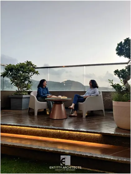 Here you can see the second terrace of the same penthouse, designed for enjoying the scenic view. We used a simple wooden deck and a clear glass railing to keep the focus on the landscape. This space shows how we create functional outdoor seating areas perfect for quiet moments or conversations.