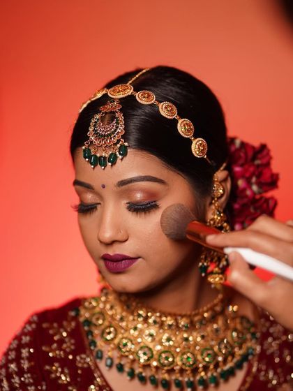 The finishing touches. A light dusting of powder sets the makeup, ensuring a long-lasting, shine-free finish for this beautiful bride.