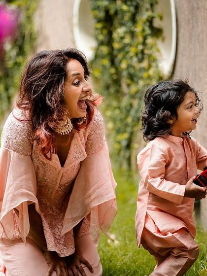 A candid shot of a mother and her young son sharing a moment of discovery by a garden wall. We follow your family's lead, capturing your interactions as they naturally unfold.