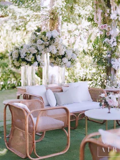 A lounge area from our 'Romantic Garden' wedding in Bali. The design incorporated a harmonious fusion of natural cane furniture and lush white floral installations.