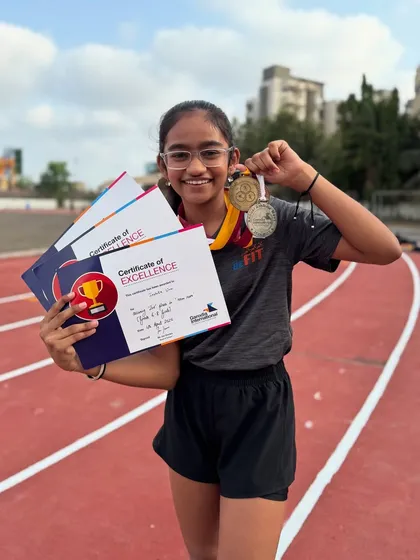 Celebrating our athlete Irshita Unni, who proudly displays her three medals and certificates from her school's Annual Athletics meet. Consistent effort pays off.