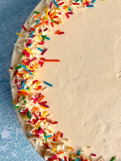 A top-down view of the Vanilla Vanilla cake, showing the colourful sprinkles on the smooth buttercream frosting.