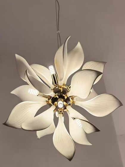 A flower-shaped chandelier with large, elegant petals. This fixture provides a soft, ambient light and serves as a beautiful sculptural element.