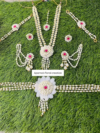 A classic Dohale Jevan set made from fragrant jasmine buds and accented with pink stones. This set includes a long necklace, choker, kamarband, maang tikka, earrings, and haath phool.