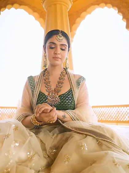 A serene portrait of a bride styled in traditional temple jewellery. The layered necklaces and maang tikka create a complete, regal look, perfect for a South Indian wedding ceremony.