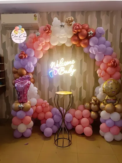 A beautiful 'Welcome Baby' balloon ring in pastel colors with a neon sign, perfect for a photo backdrop.