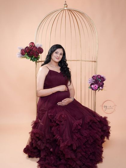 A beautiful solo portrait using our golden birdcage prop. The deep maroon gown and floating floral accents create a magical and artistic look.