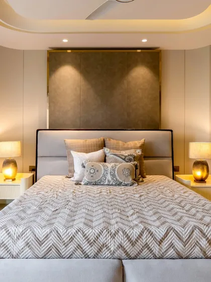 A closer look at the details of this cozy bedroom. The textured headboard, patterned bedding, and warm bedside lamps come together to create a space that is both stylish and deeply comfortable.