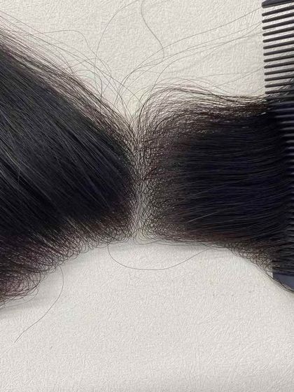 Combing through the parting of a custom piece. The hair appears to be growing directly from the scalp, showcasing the quality of our fine knotting.