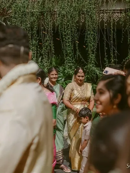 An over the shoulder, documentary style shot that places you right in the middle of the event. This photo captures the authentic atmosphere and the smiling faces of guests at a family gathering.