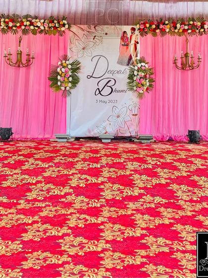 A beautiful stage setup for a day function. I used bright pink drapes with a personalized welcome banner and floral chandeliers to create a celebratory look.