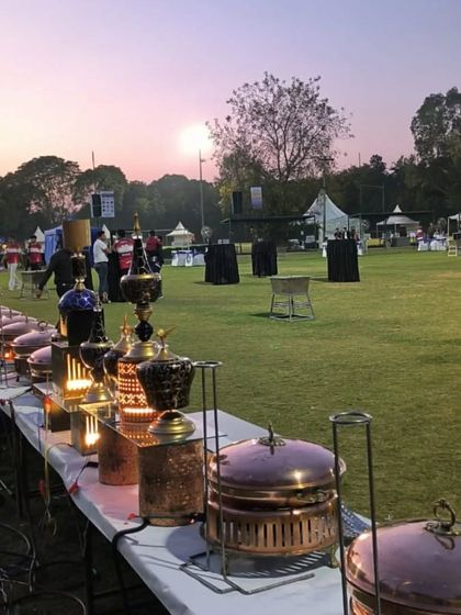 The sun sets over our stunning outdoor buffet line. The warm glow on the copper serveware highlights the care we put into creating a memorable dining experience, no matter the location.