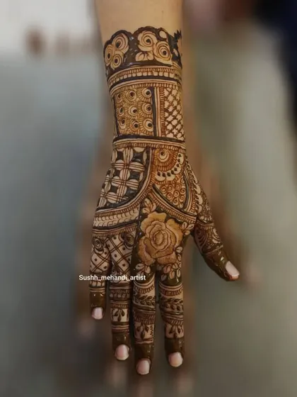 A single-hand design that is both intricate and elegant. The rose motif on the thumb is a lovely detail.