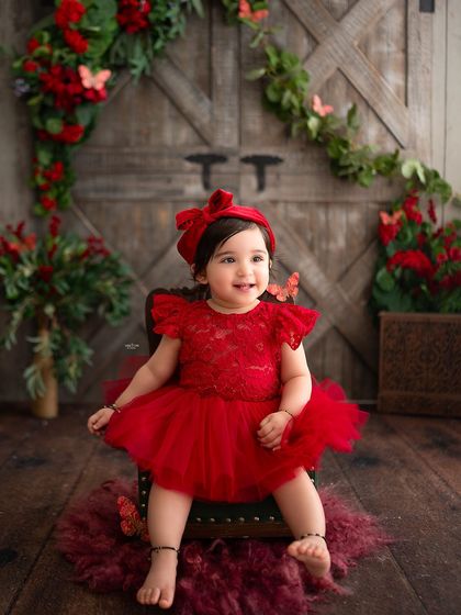 Posing like a little lady in her red dress.