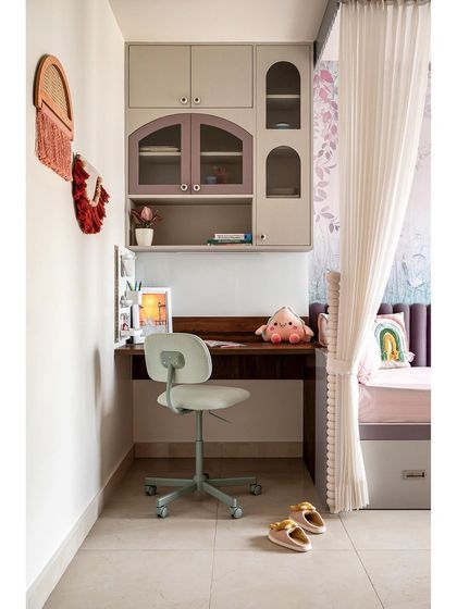 The study table in the kids' room features charming arch-shaped cabinets for storage. The entire space is designed with a mix of playful pastels and functional furniture to create a room that is both fun and practical.