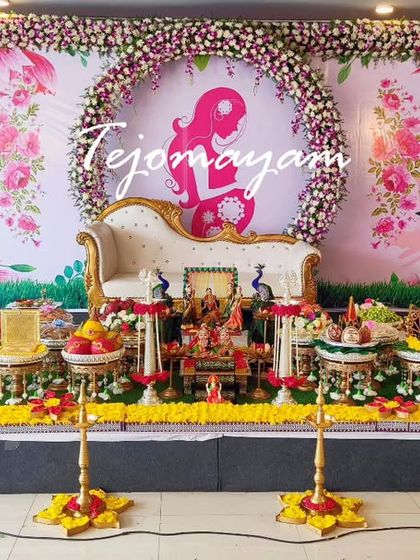 A lovely baby shower setup with a floral arch and a backdrop featuring a mother's silhouette, creating a modern and heartfelt theme.