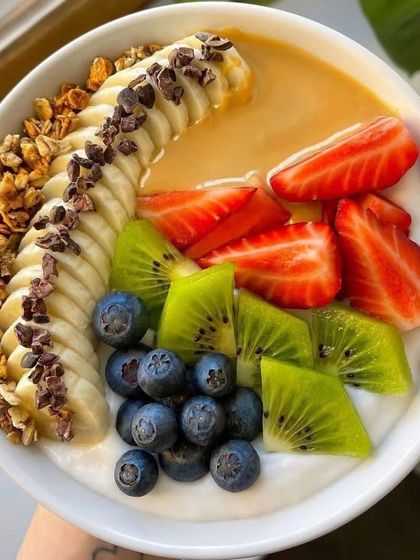 A beautiful and healthy smoothie bowl to kickstart a morning event. This one is topped with fresh banana slices, strawberries, kiwi, blueberries, granola, and a drizzle of peanut butter.