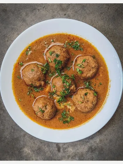 A bowl of my Khaima Unde Saaru, showcasing the perfectly formed minced lamb meatballs in a rich, aromatic gravy.