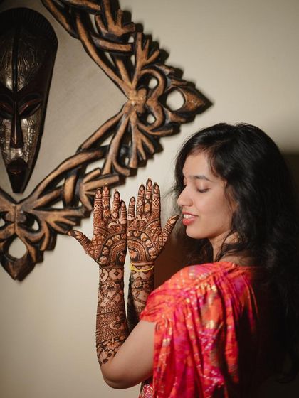 A bride admiring her beautiful and detailed traditional mehndi.