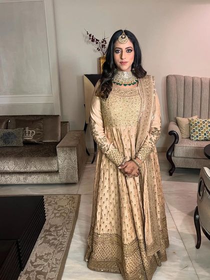 A full shot of the client in her beautiful traditional outfit, her makeup looking soft and natural.