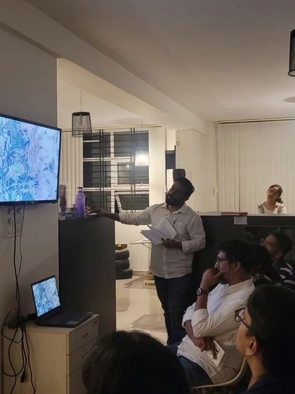 A speaker points to a map during a presentation. Our work is often rooted in deep research and an academic understanding of place, which we love to share with our community.