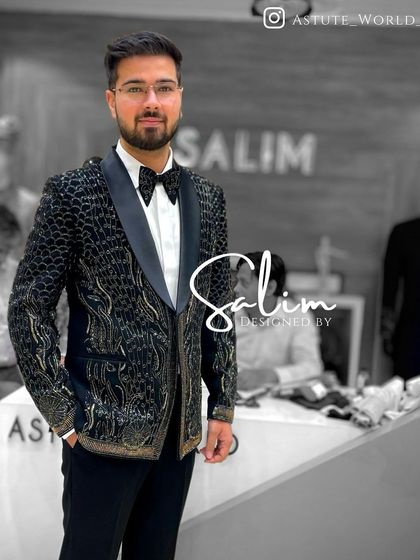 A client in a black tuxedo jacket with a textured, snakeskin-like pattern and gold accents. This is a luxurious and bold choice for a fashion-forward individual.