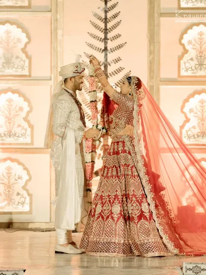 The exchange of garlands, a timeless tradition symbolizing love and acceptance. The bride and groom share a look of pure happiness.