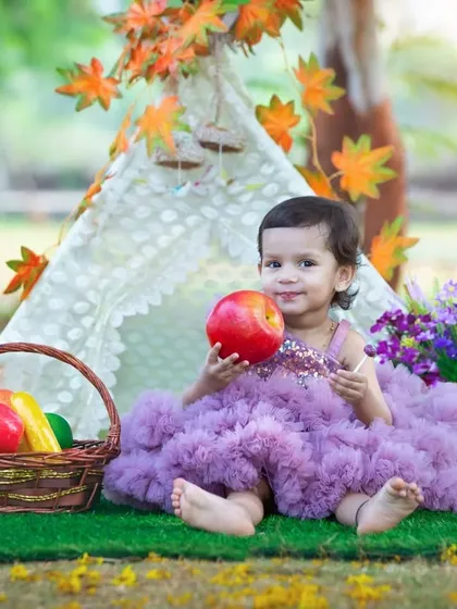 An apple for the little princess in her magical teepee. This setup is perfect for a second birthday, creating a whimsical and colorful backdrop for her portraits.