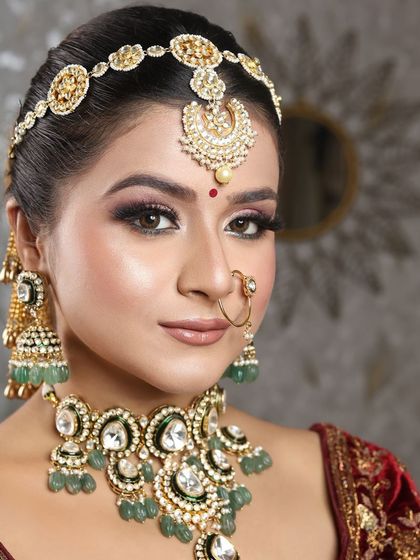A close-up of this bride's regal look, focusing on her expressive eyes and the beautiful matha patti that frames her face.